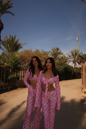 תחפושת ברבי ורודה , חליפת 2 חלקים מבד לייקרה מחטב עם הדפס Barbie הכוללת חולצת קשירה עם שרוולים ארוכים מתרחבים , ומכנסיים ארוכים בסגנון פדלפון למראה תואם ואחיד.